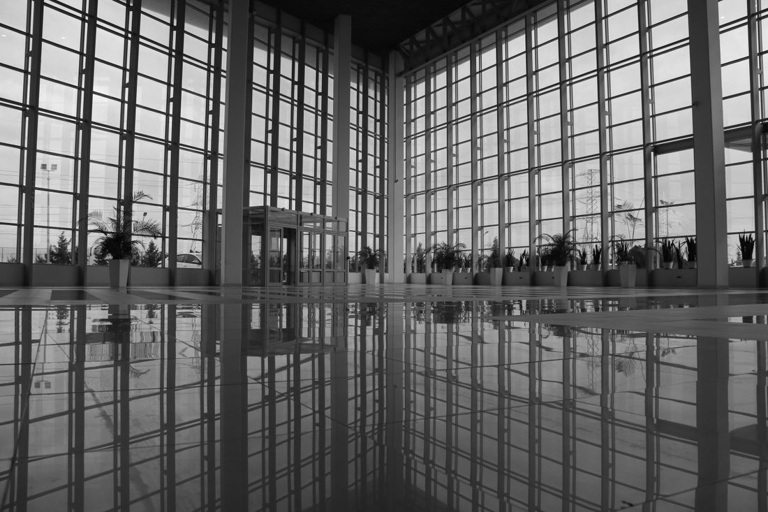Spacious modern atrium interior with large glass windows and contemporary architecture.