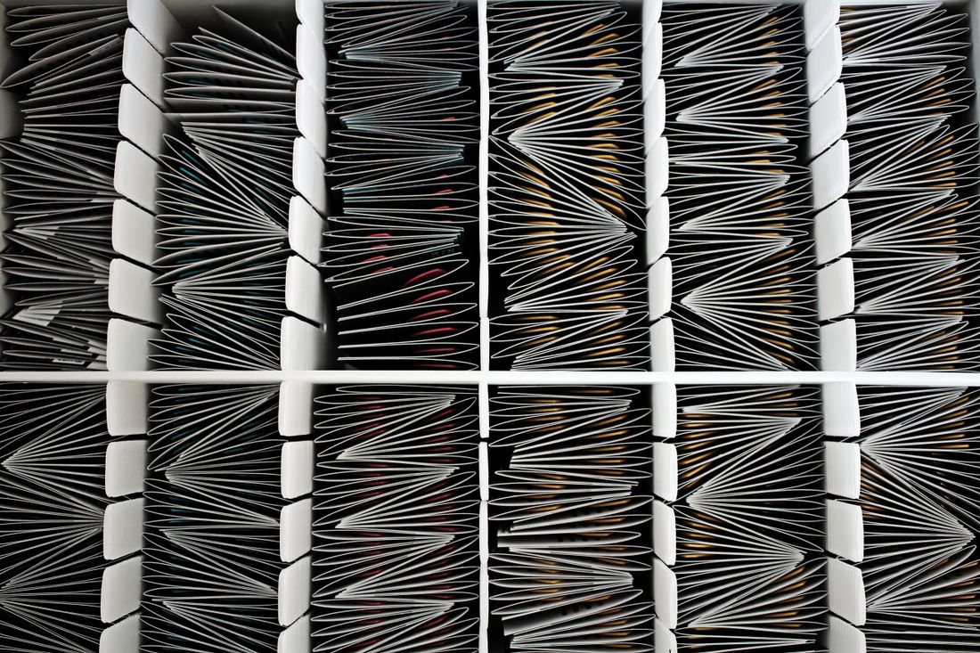 A close overhead view of paper works organized in divided archive folders