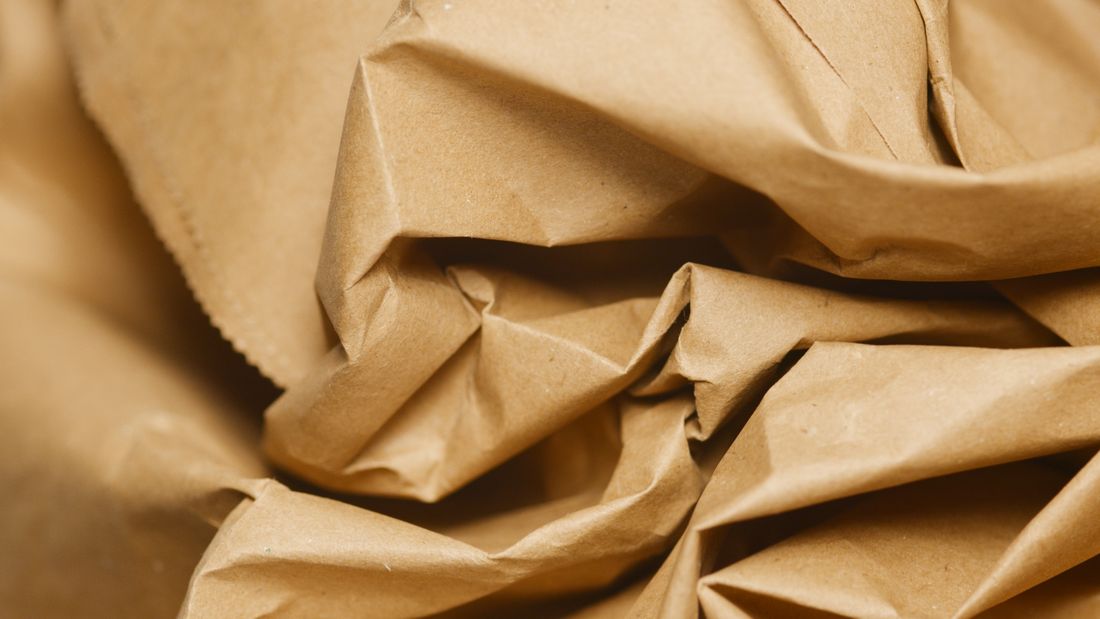Detailed close-up of crumpled brown kraft packing paper texture