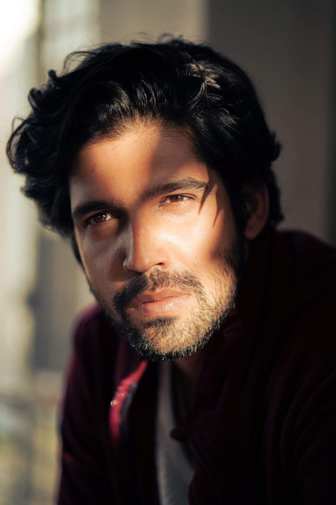 A close crop portrait of a man's face in soft directional light, calm and steady expression
