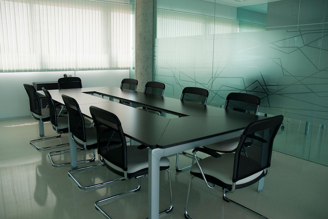 Elegant conference room with sleek black chairs and a modern glass wall design.