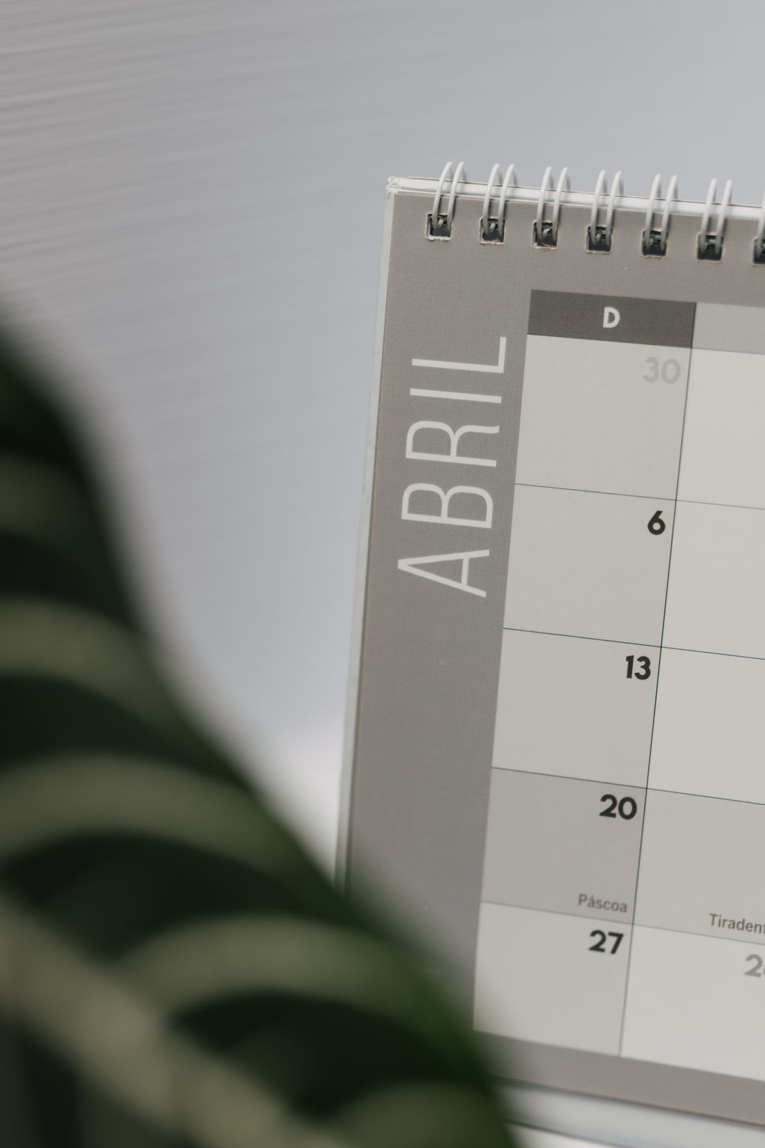 Close-up of an April calendar page with a blurred plant in the foreground.
