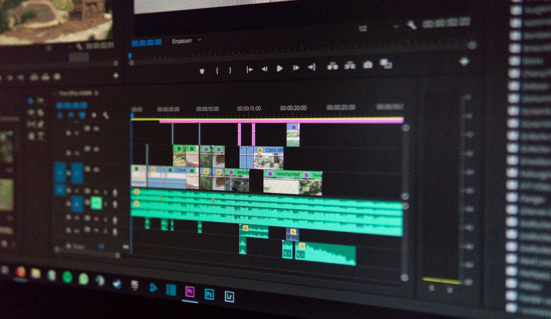 Close-up of a video editing timeline with waveforms and clip thumbnails on screen