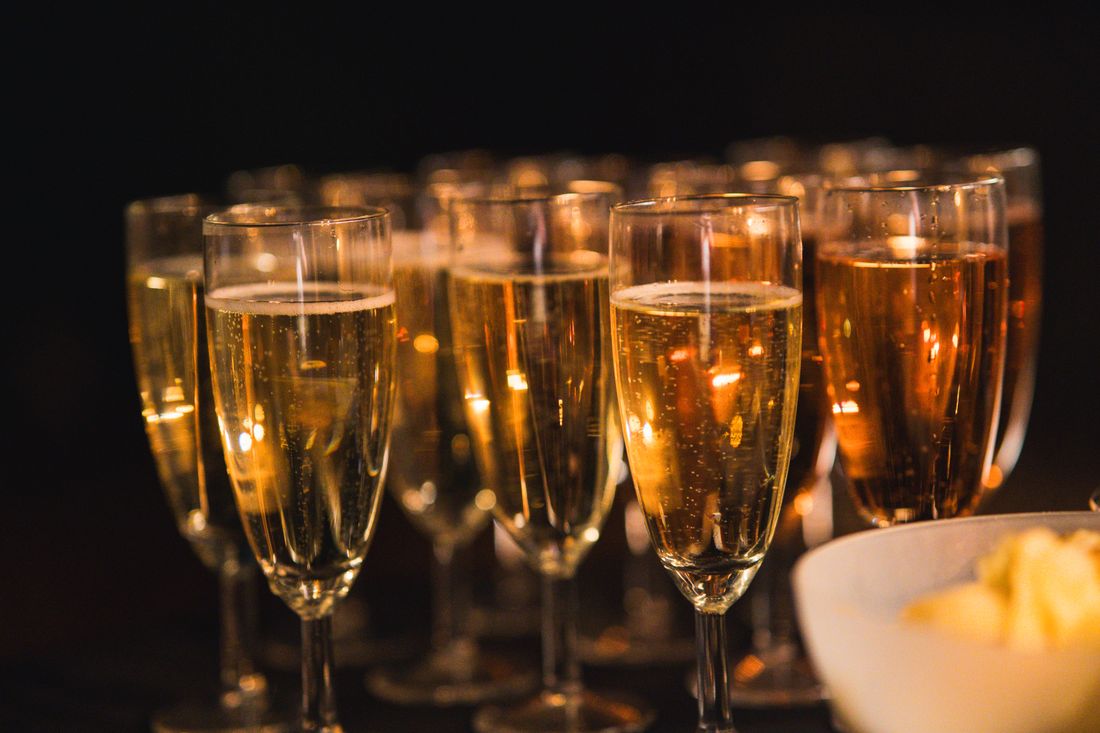 A close-up of champagne glasses filled and arranged on a table at an evening reception
