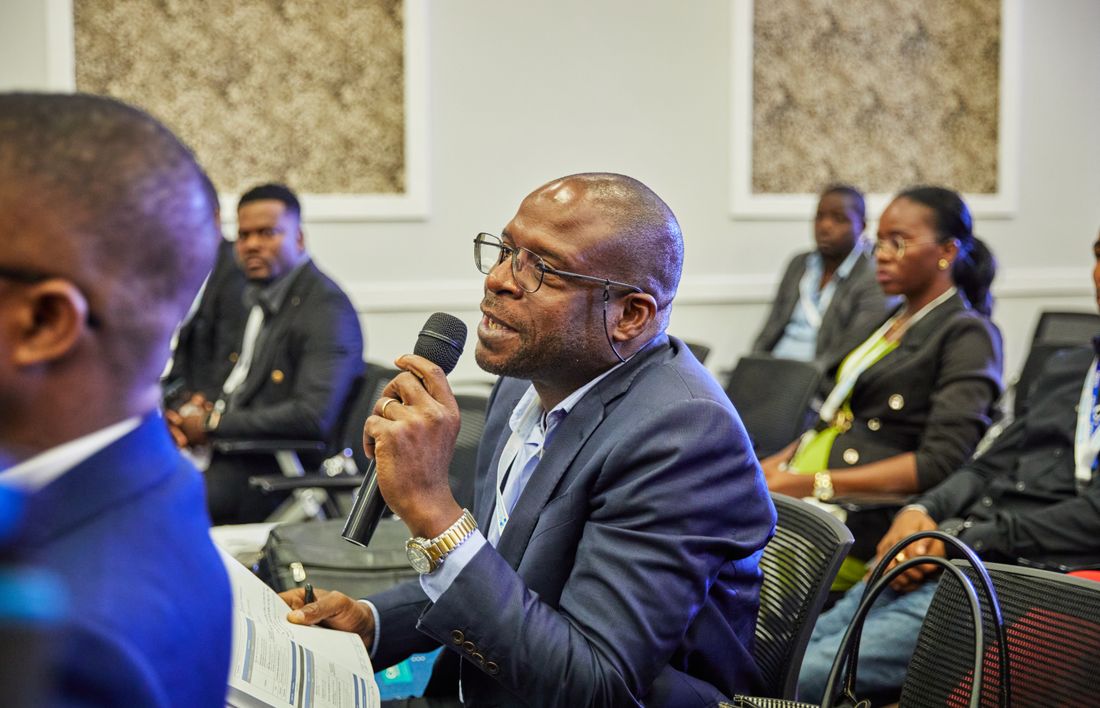 A man in the audience holding a microphone while asking a question during a conference