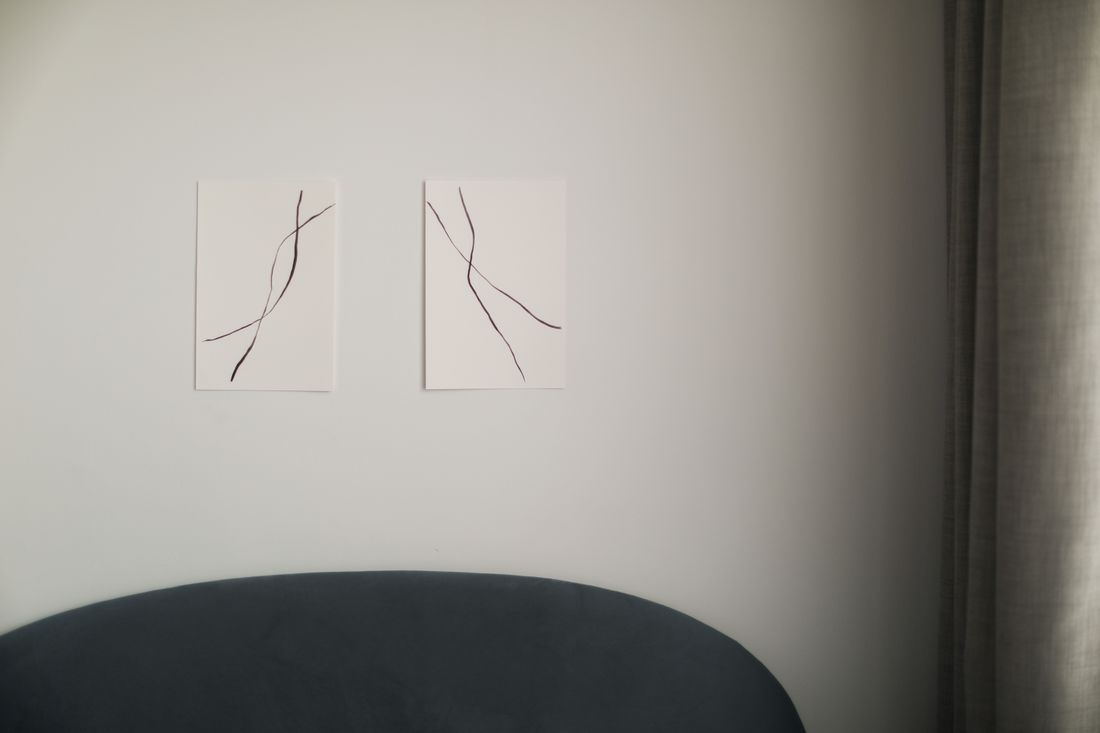Two abstract line-drawing panels installed as a diptych, evenly spaced on a white wall