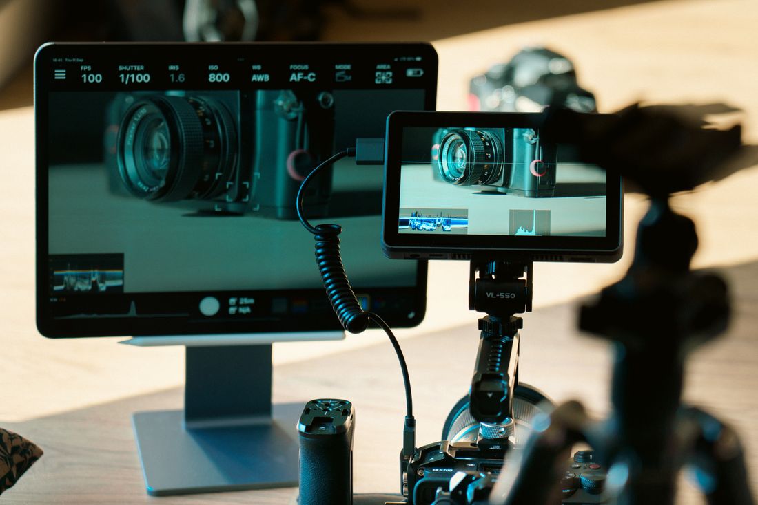 Two monitors displaying a tethered camera preview with exposure settings visible, during an on-site review