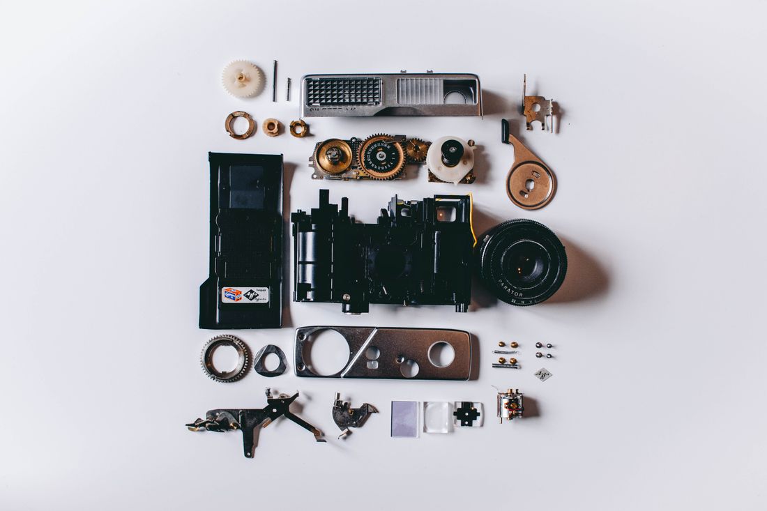 Disassembled camera parts and components laid out on a white surface