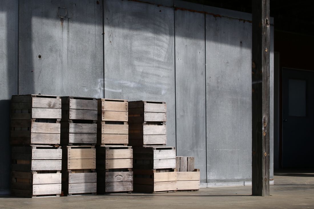 Empty wooden crates stacked against a wall in an industrial space