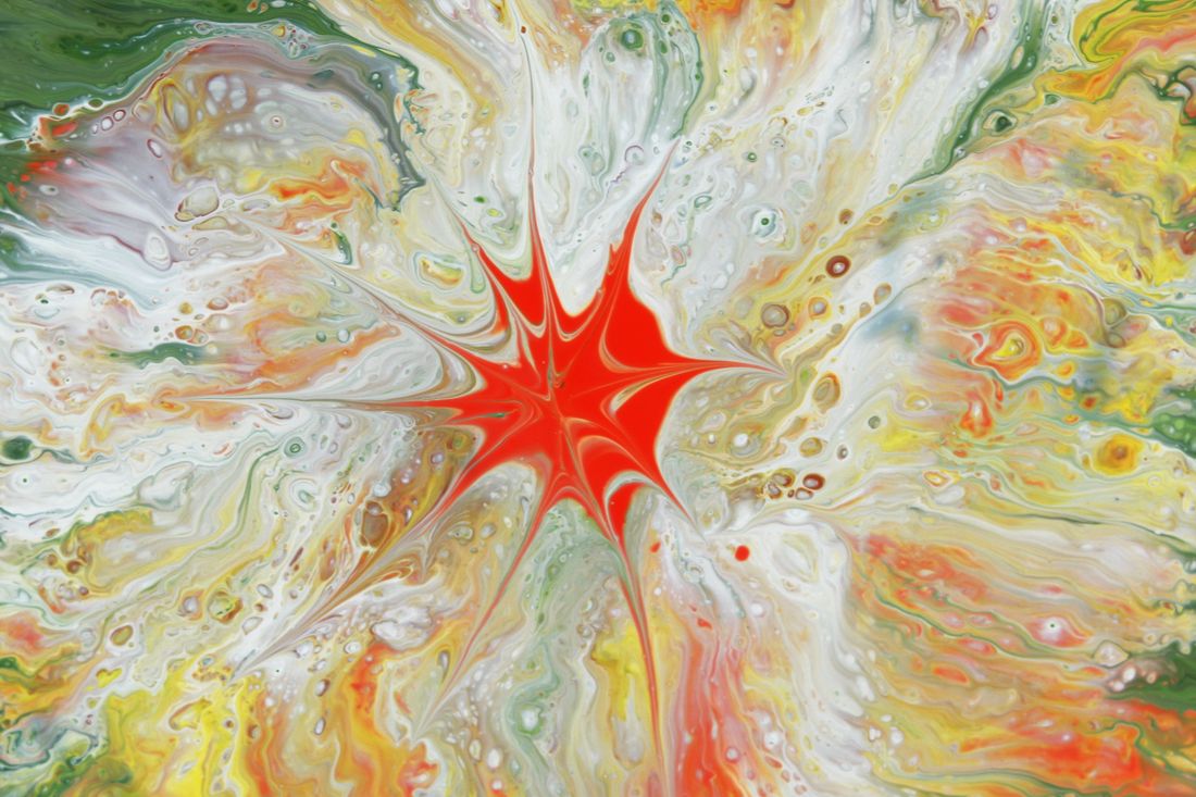 Close view of a wet poured-paint surface with swirling colors still fluid and unset, mid-process