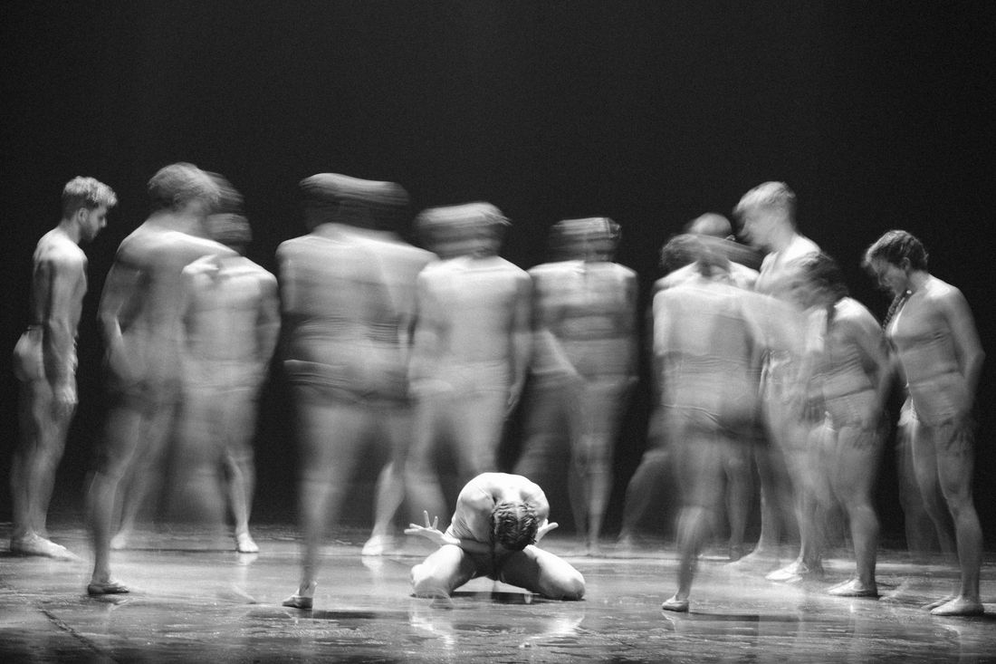 Blurred black-and-white photograph of dancers in motion during a live performance