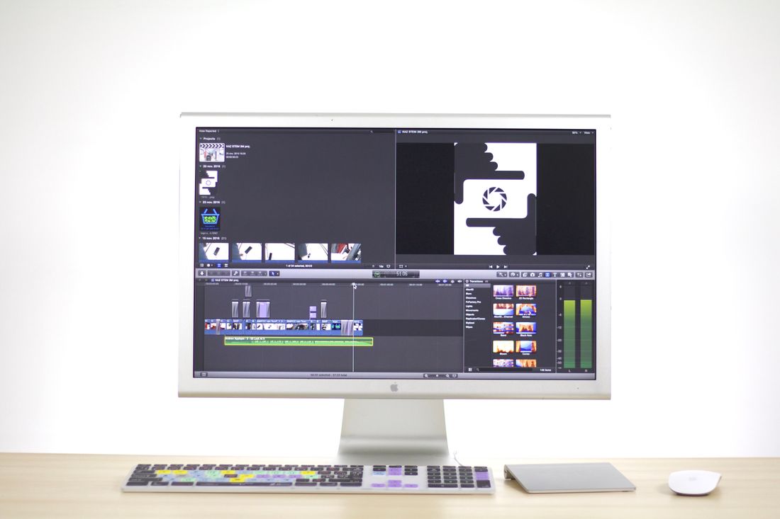 A desktop monitor displaying video editing software with a timeline, clips, and waveform panels