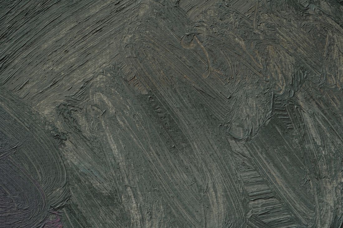 A tight close-up of a painted canvas surface, thick abstract brushstrokes catching raking side light that reveals their texture.
