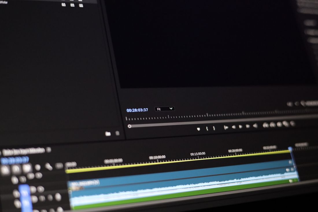 Close-up of a video editing timeline on a monitor showing a running timecode counter