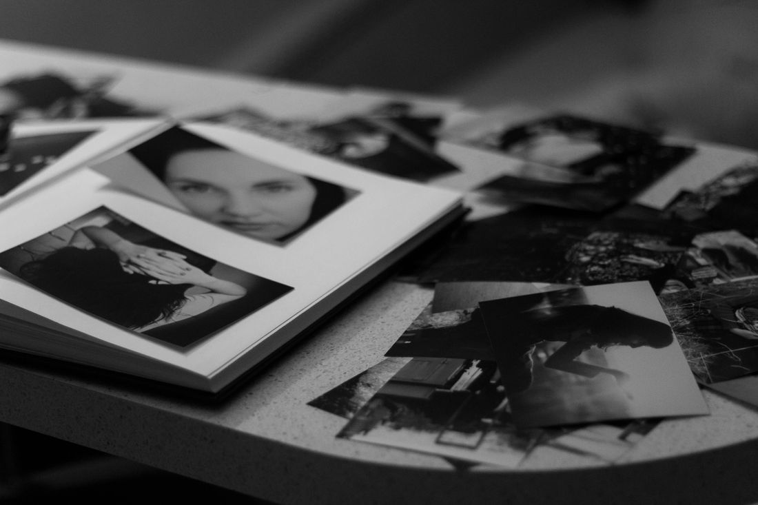 Black and white photos scattered across a table, spread out for review