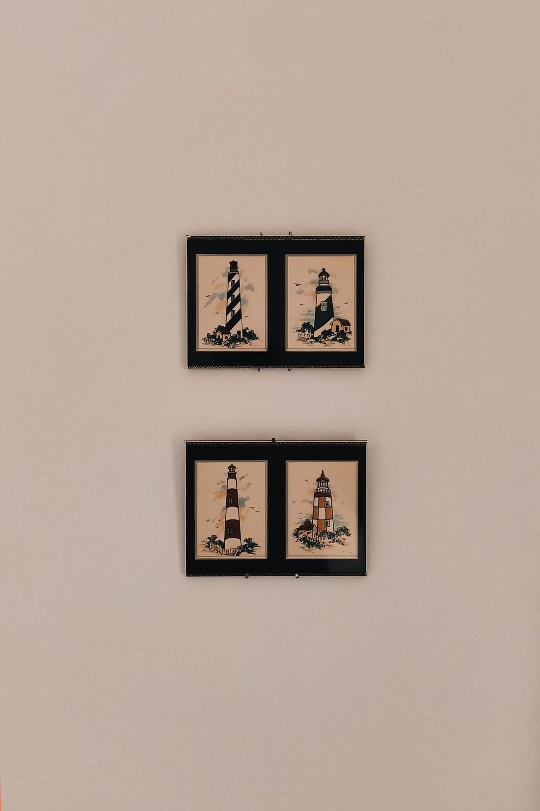 Two small framed prints hung in an evenly spaced grid on a plain wall.