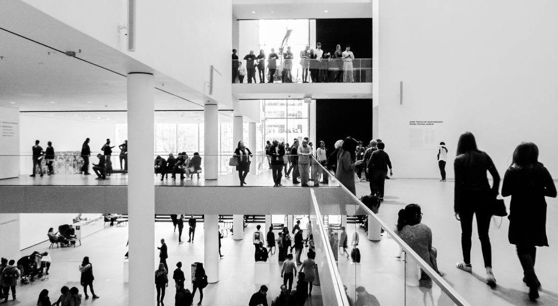 Black and white photo of visitors browsing a multi-level museum interior