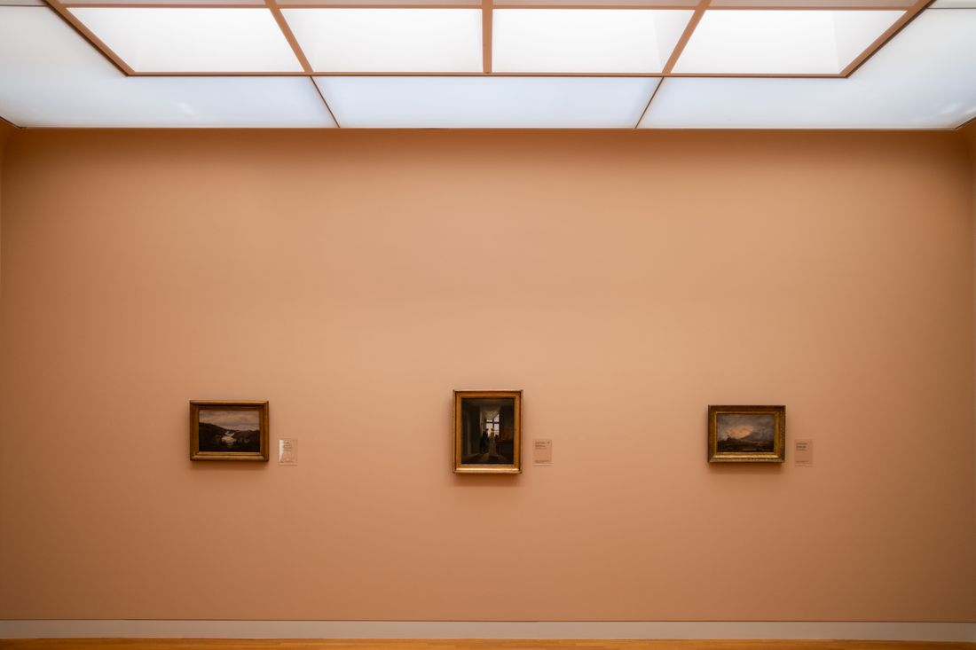 A minimalist gallery wall with three small framed paintings evenly spaced