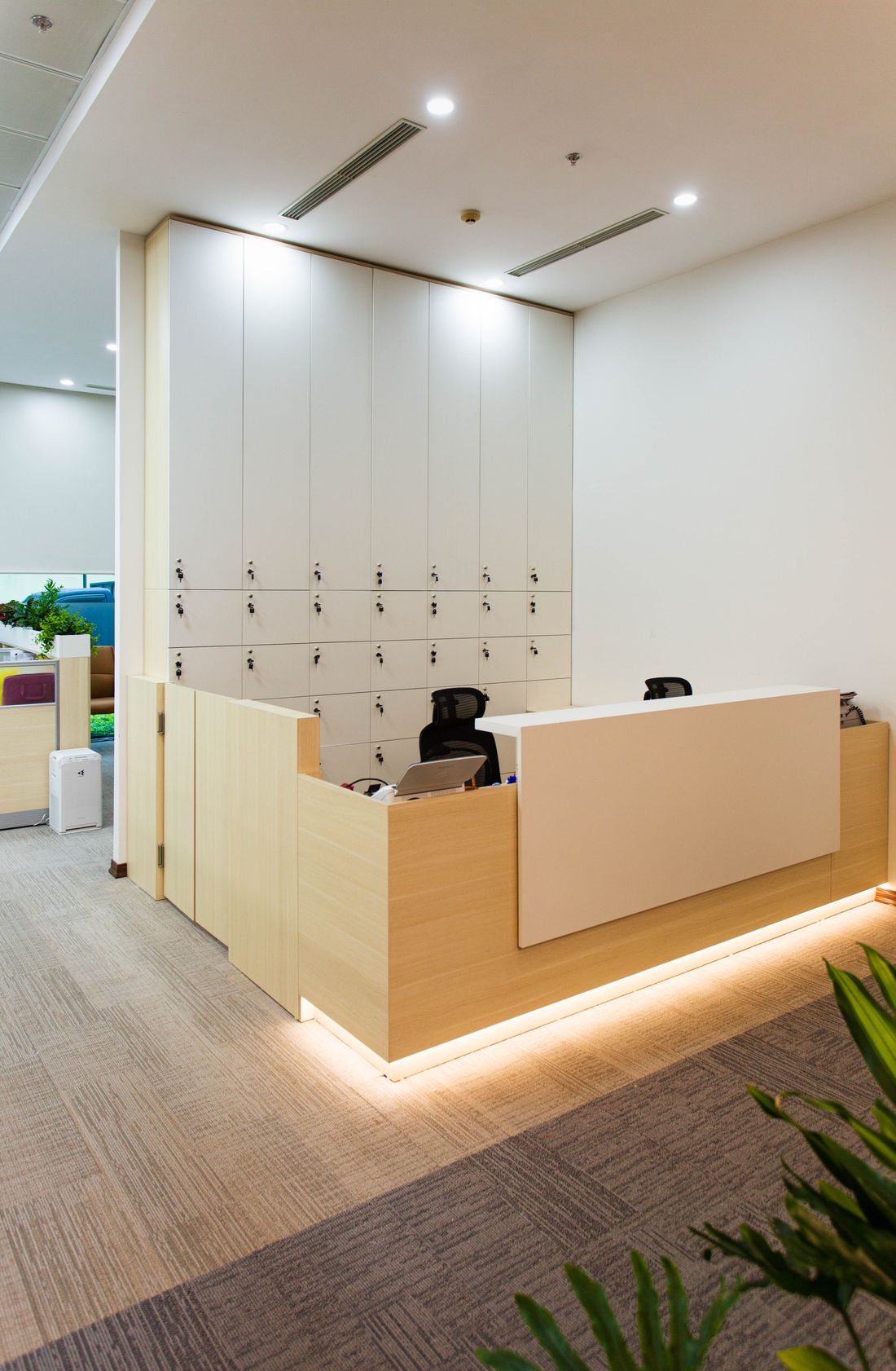 A tidy, unstaffed reception desk in a quiet office lobby, no signage or names visible.