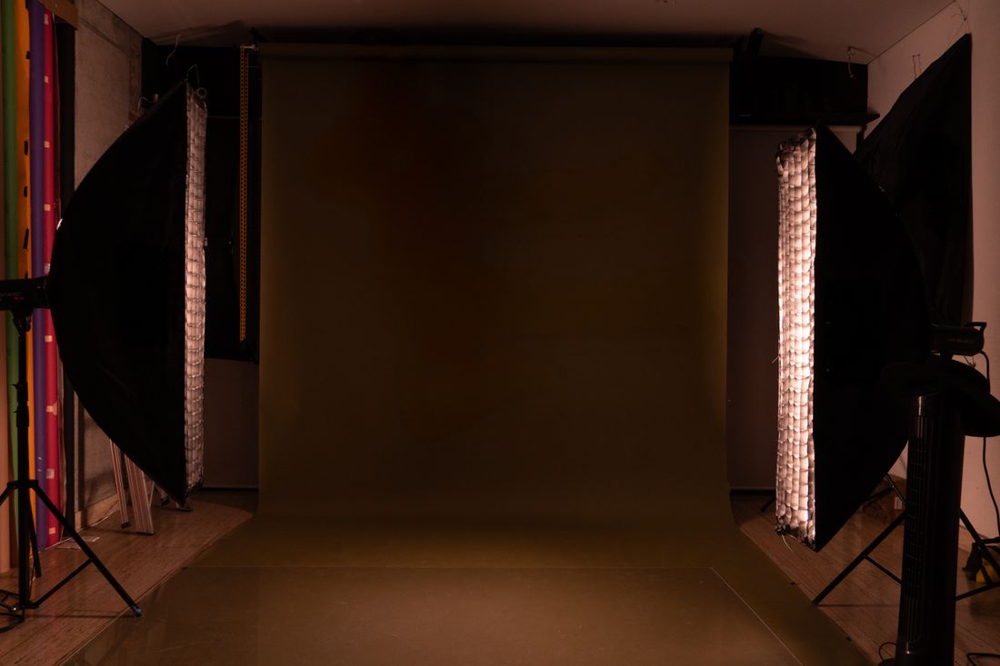 Empty photography studio backdrop lit by two softboxes on either side