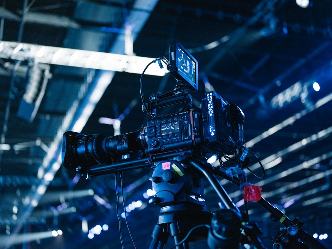 Close-up of a professional video camera setup at a well-lit indoor event venue