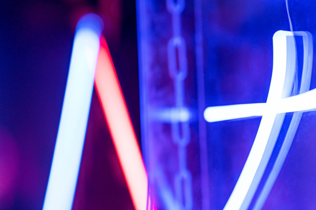 A close-up of glowing blue and red neon tubing against a dark background