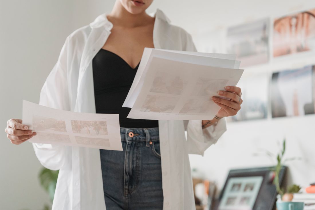 Two printed portrait photos being compared side by side on a table