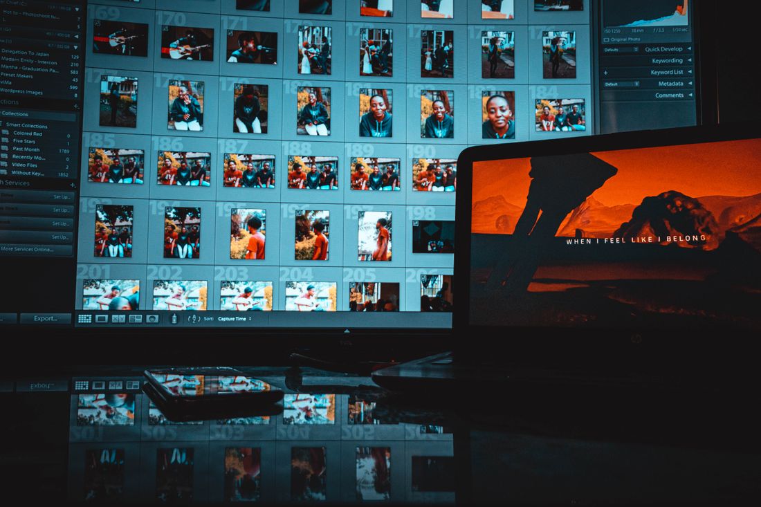 A monitor showing a grid of image thumbnails in an editing application