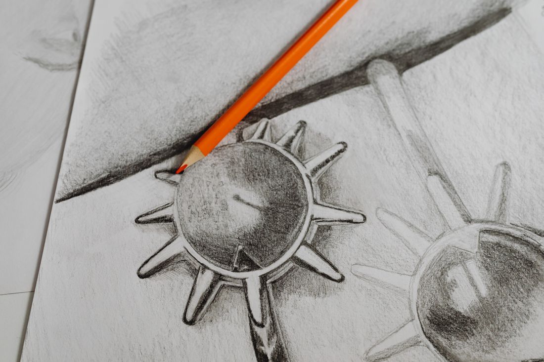 A close-up of a graphite pencil drawing on paper showing pencil shading and sheen