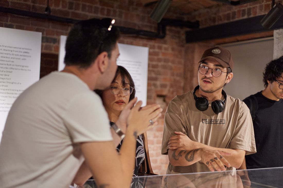 A small group of people gathered in conversation at an intimate gallery space