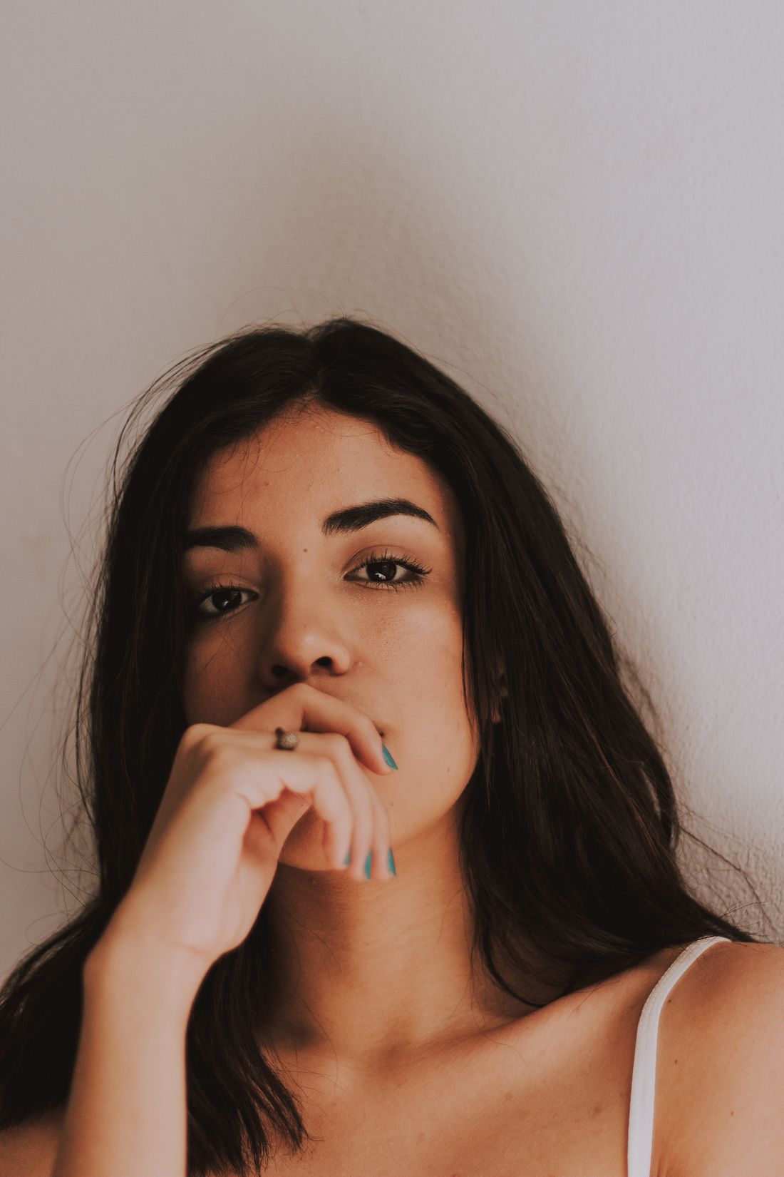 A close portrait of a person against a plain background, neutral expression