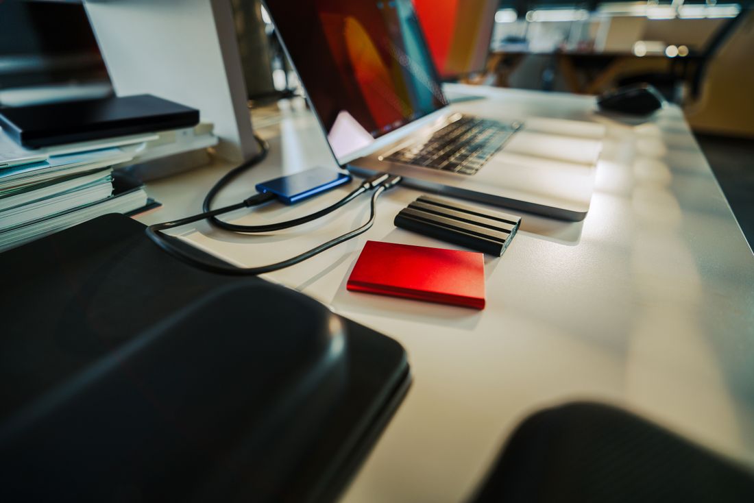 Modern desk with a laptop and two external hard drives arranged neatly for organizing files