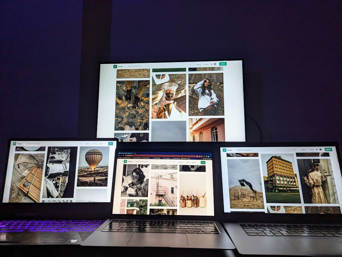 Several laptop screens displaying grids of photographs side by side, similar to a portfolio website layout