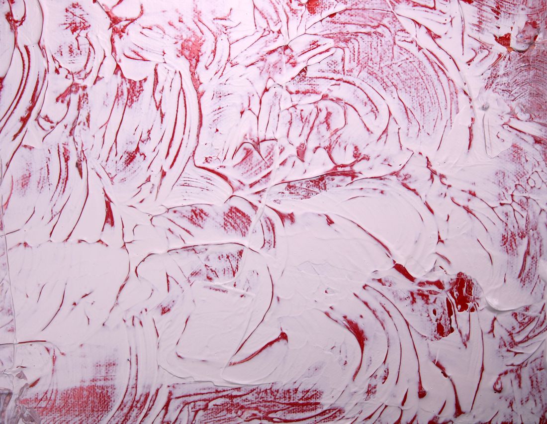 Close-up of thick white and red paint with a wet, glossy texture and visible brush ridges